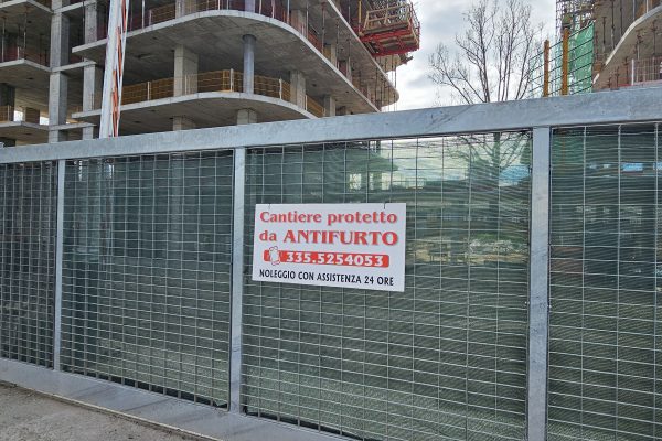 Cantiere edilizio con cartello antifurto sulla recinzione