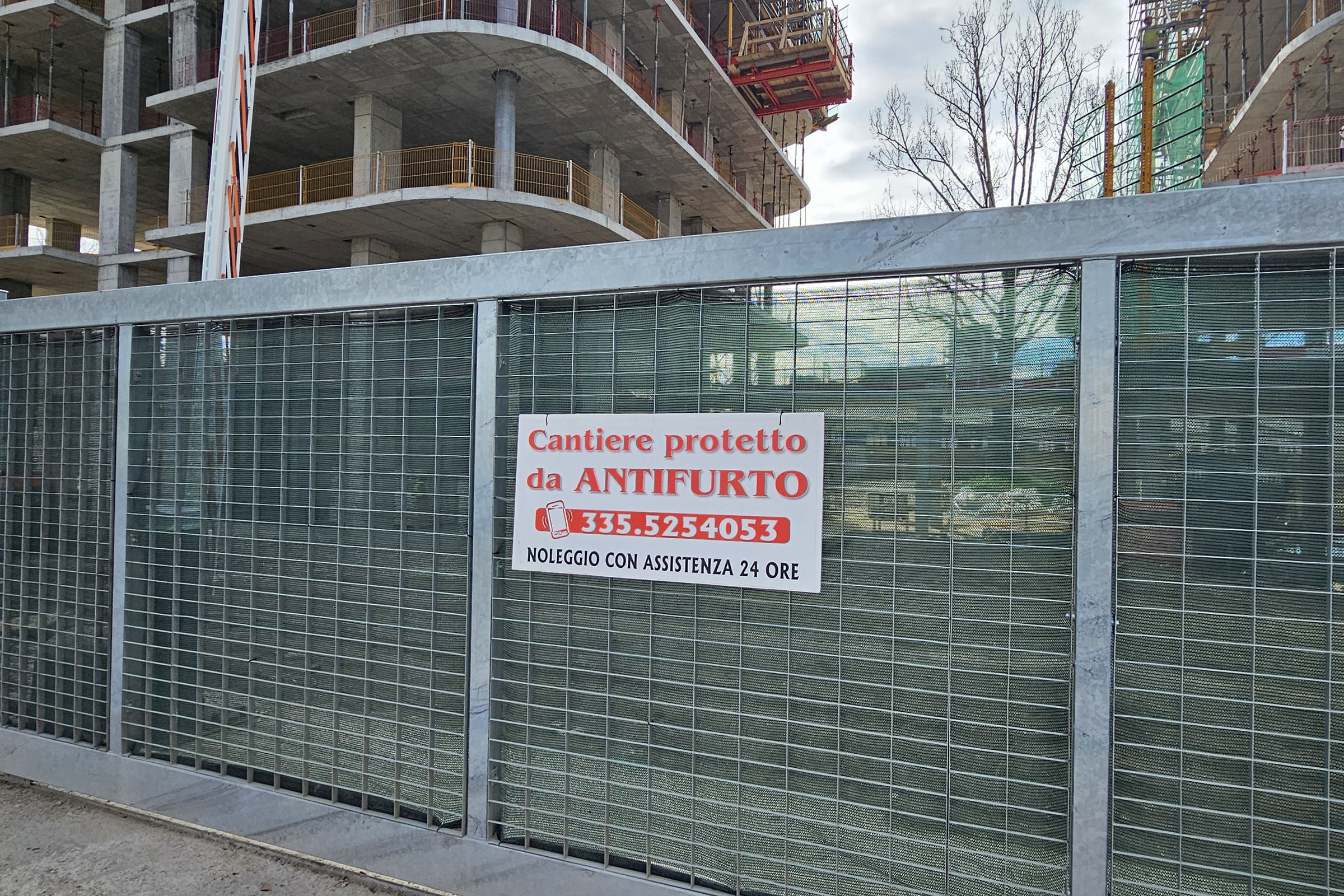 Cantiere edilizio con cartello antifurto sulla recinzione