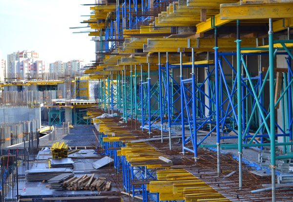 Cantiere edile con impalcature metalliche e travi in legno