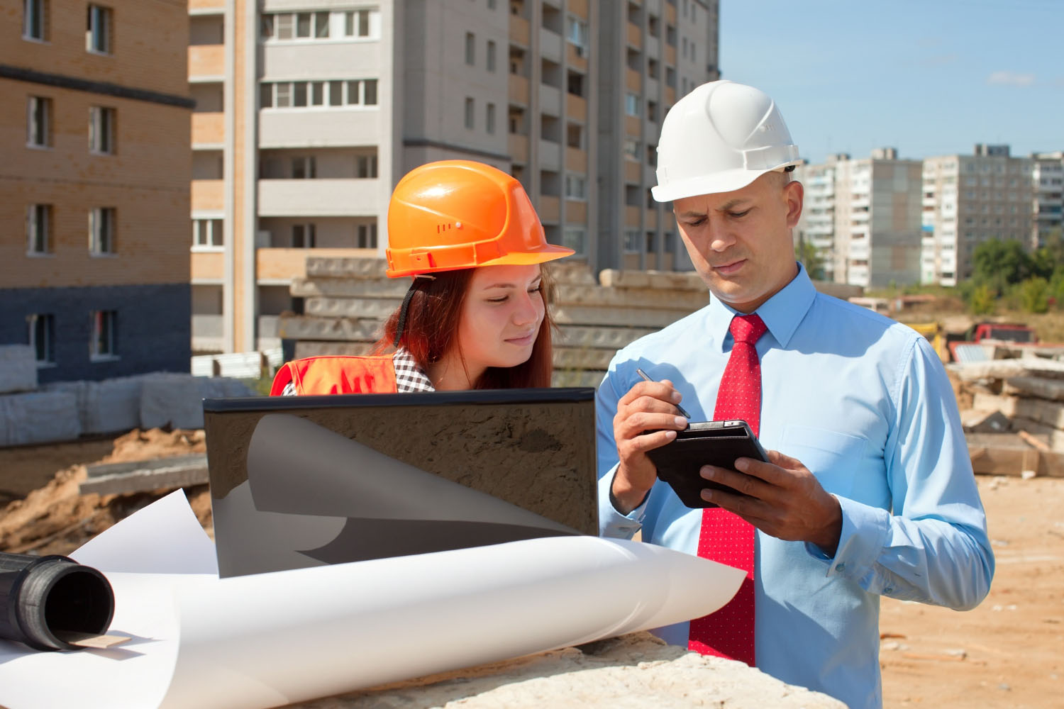 Ingegneri con caschi esaminano progetti in cantiere