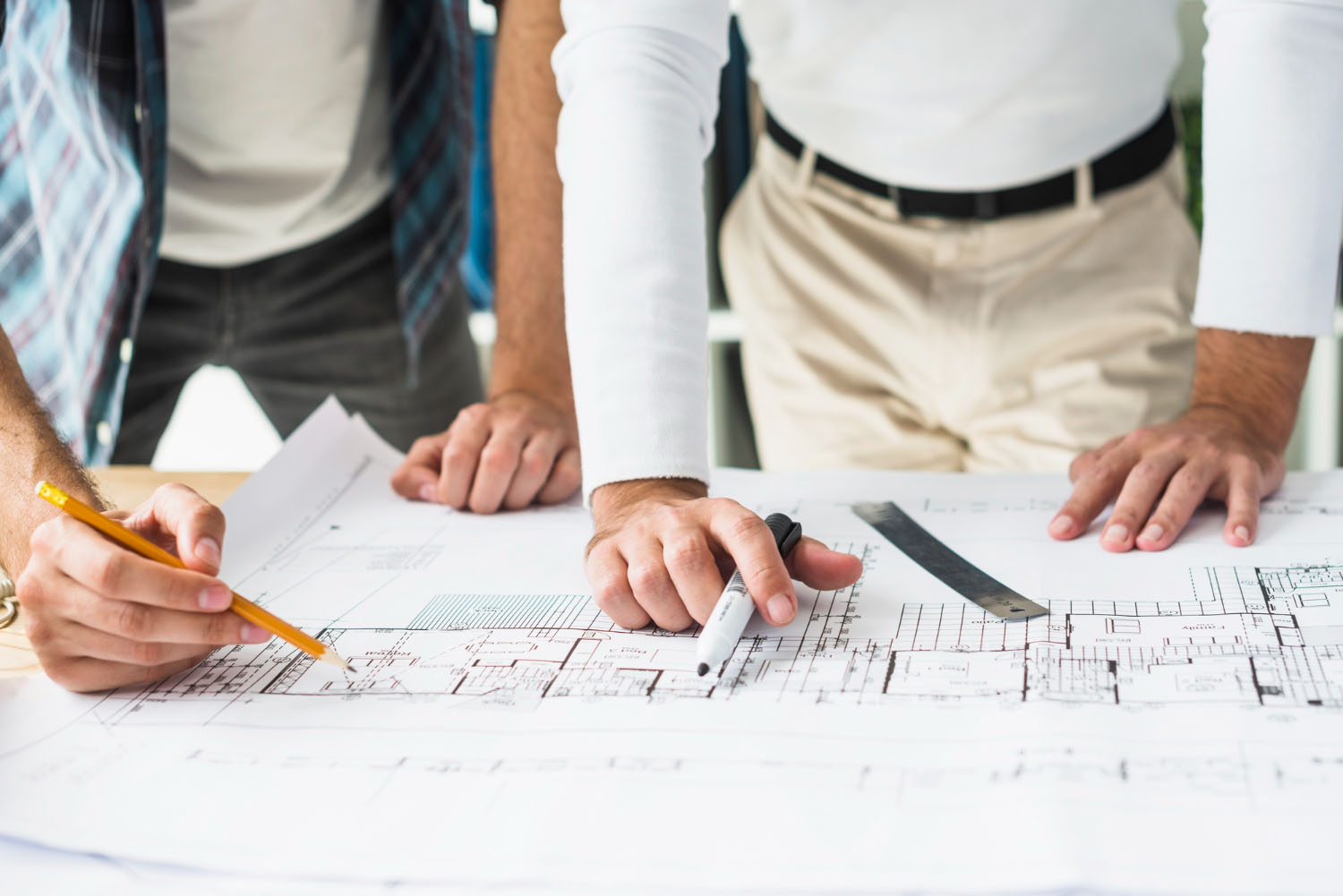 Due professionisti esaminano planimetria architettonica su tavolo